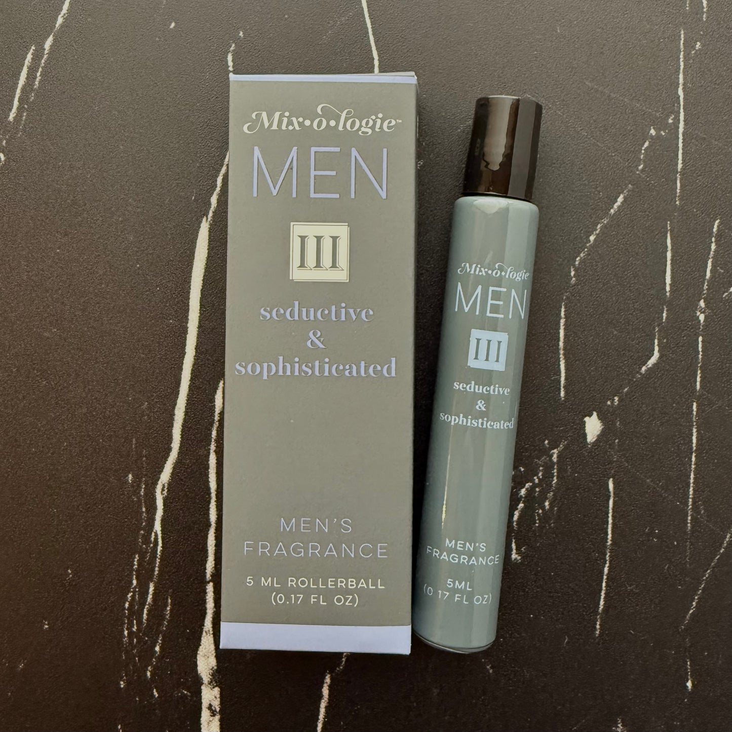 Men's fragrance rollerball and packaging on a textured brown background