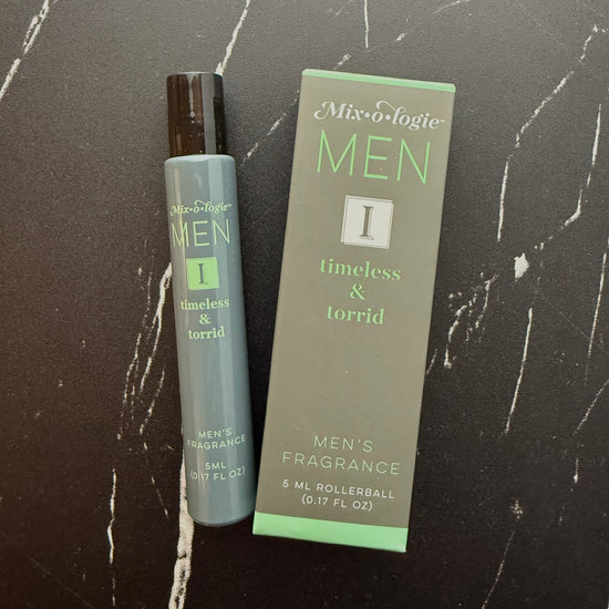 Men's fragrance rollerball and packaging on a dark marble surface