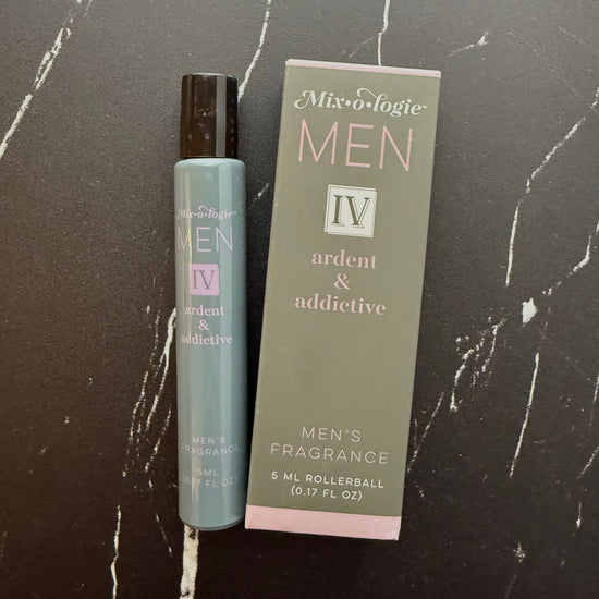 Men's fragrance rollerball and packaging on a dark marble surface