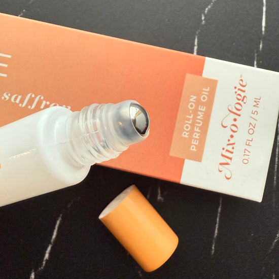 Roll-on perfume oil with packaging on a dark surface