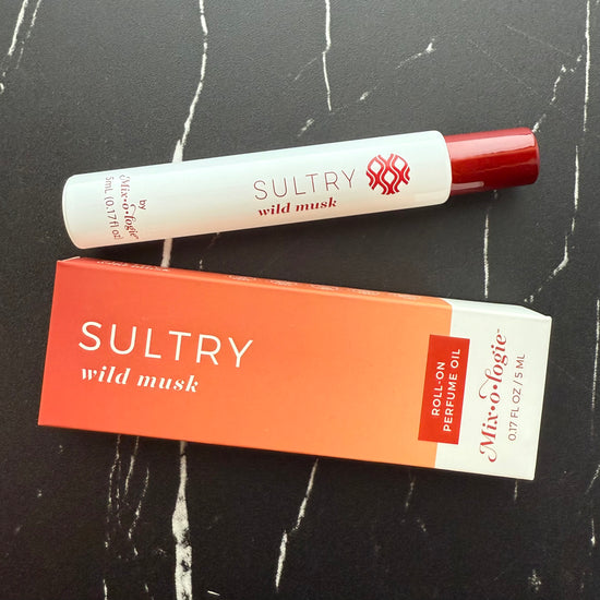 Sultry wild musk roll-on perfume oil with packaging on a black surface