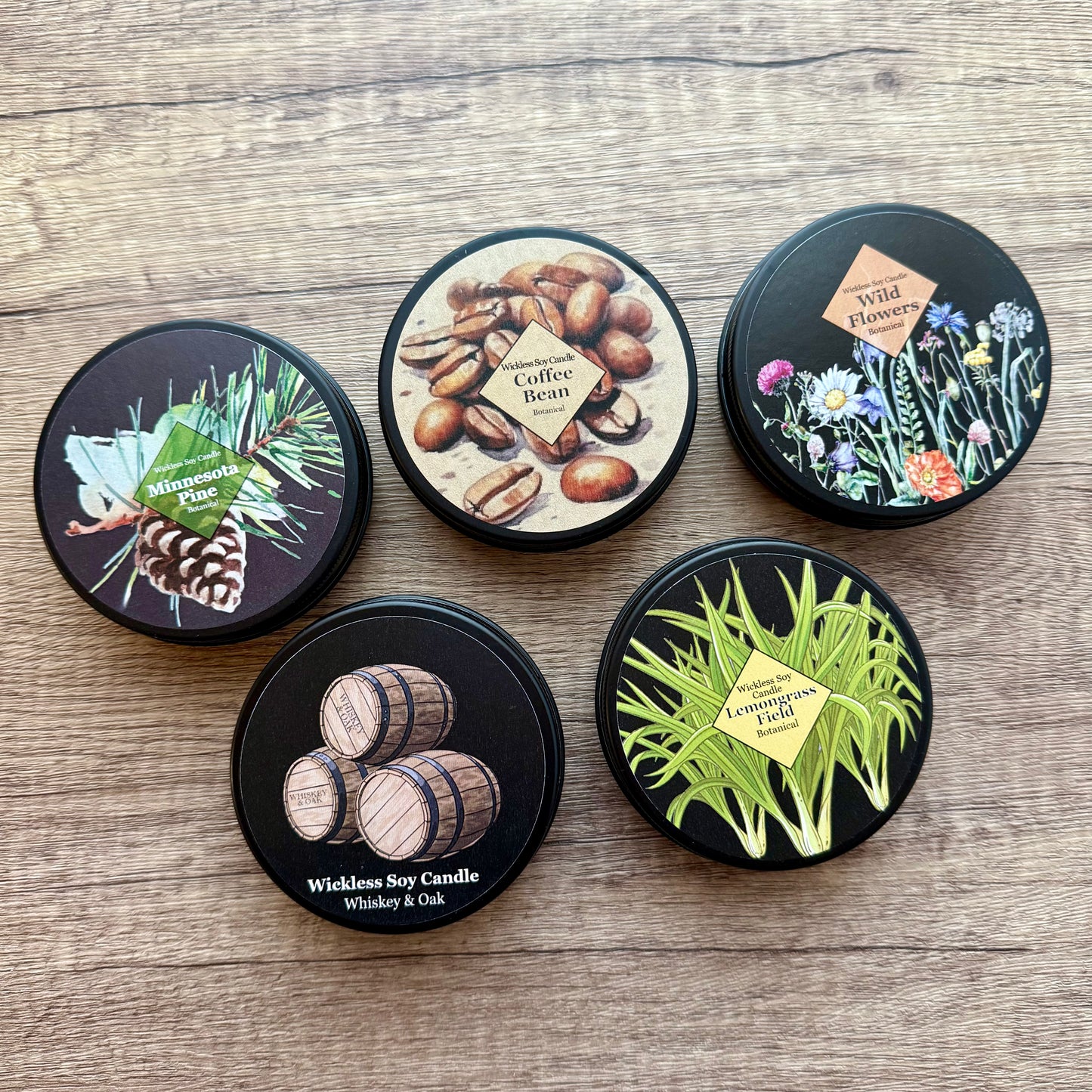 Five black lids with printed designs on a wooden surface