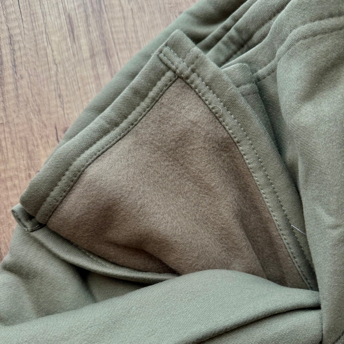 Close-up of green fabric with a wooden surface background