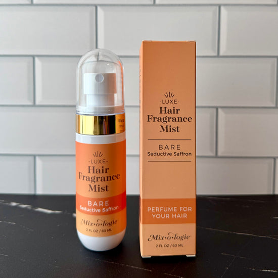 Hair fragrance mist bottle and packaging on a tiled surface