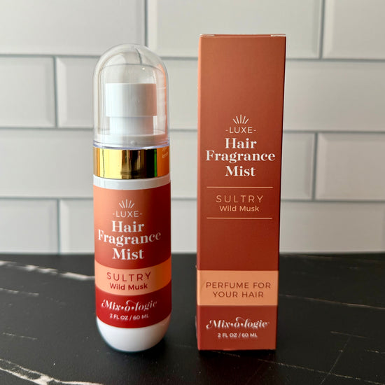 Hair fragrance mist bottle and packaging on a tiled surface